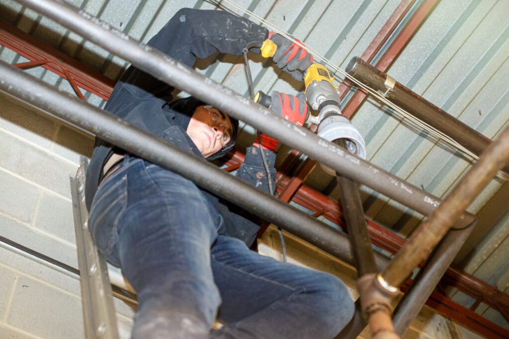 Plumbing maintenance being performed by a professional plumber using a power tool to install and maintain home water systems efficiently.