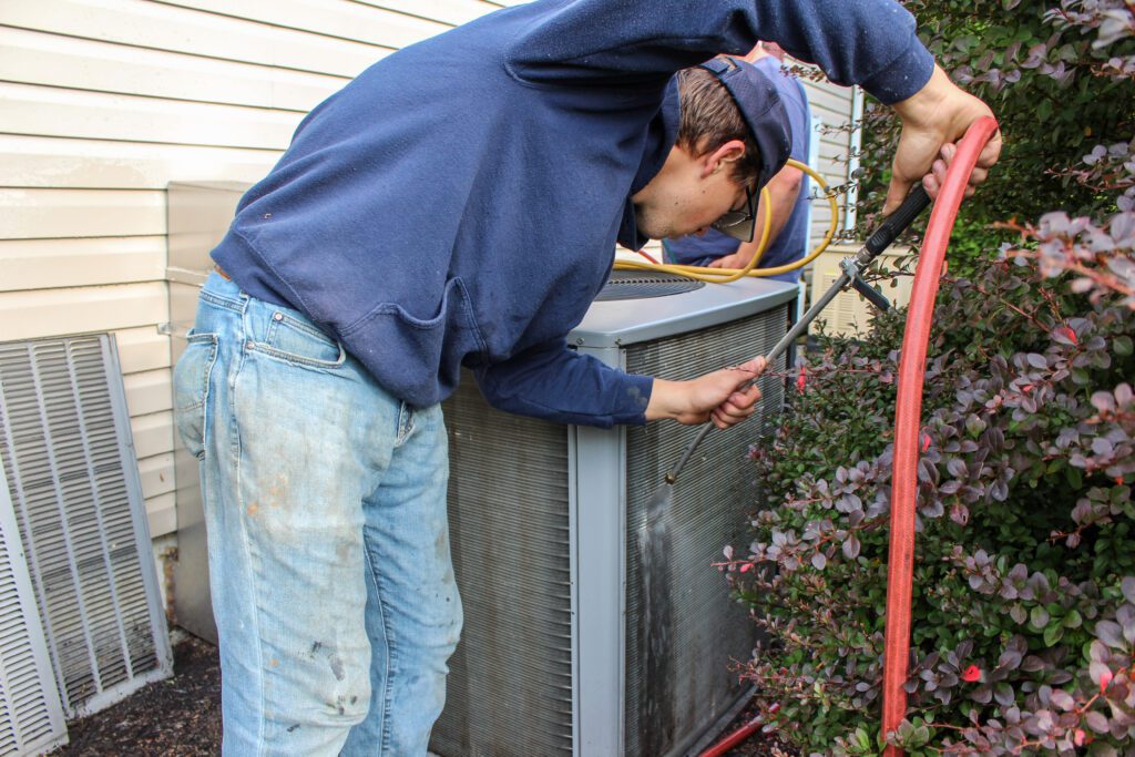 A certified technician maintains a commercial HVAC system as part of comprehensive commercial construction services, ensuring operational efficiency.