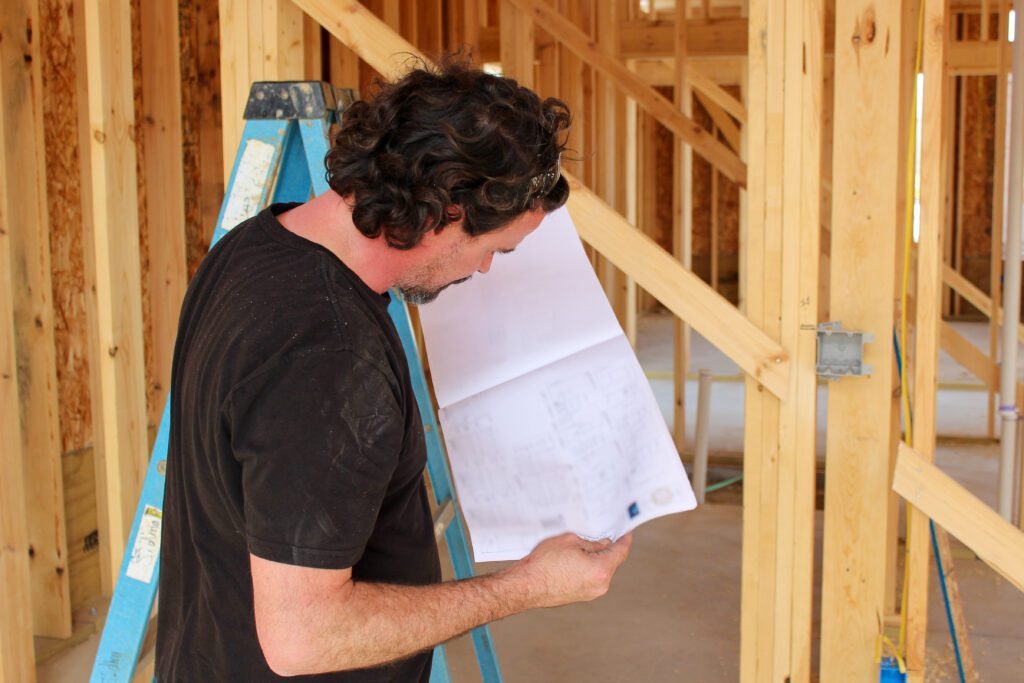 Custom home construction company showcased as a contractor reviews a blueprint, highlighting planning, precision, and expert craftsmanship for a new home project.