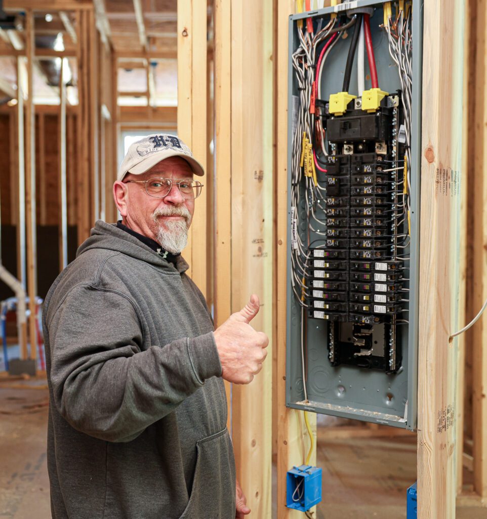 A professional Goodridge electrician performs commercial electrical surge protection installation, securing a commercial facility’s electrical panels to prevent power spikes and protect equipment.