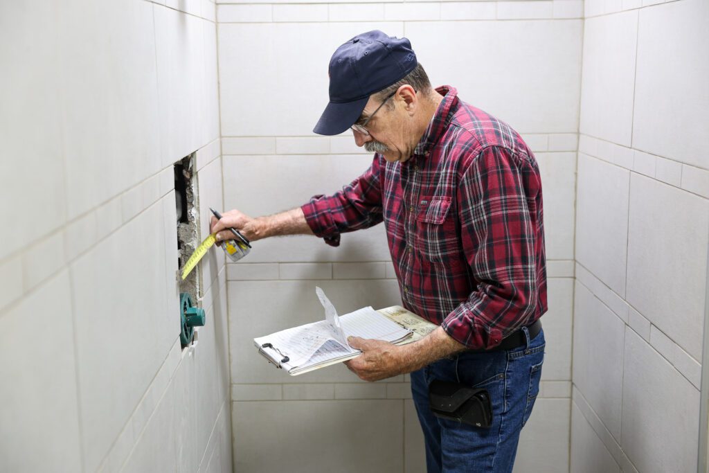 Goodridge Construction plumbing contractor performing plumbing repair and maintenance during bathroom installation, providing affordable emergency plumbing services and expert inspections for precise work.