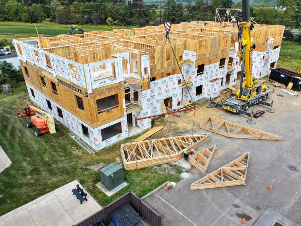 Workers frame and prepare a new apartment complex, demonstrating professional commercial construction services with precise coordination and planning.