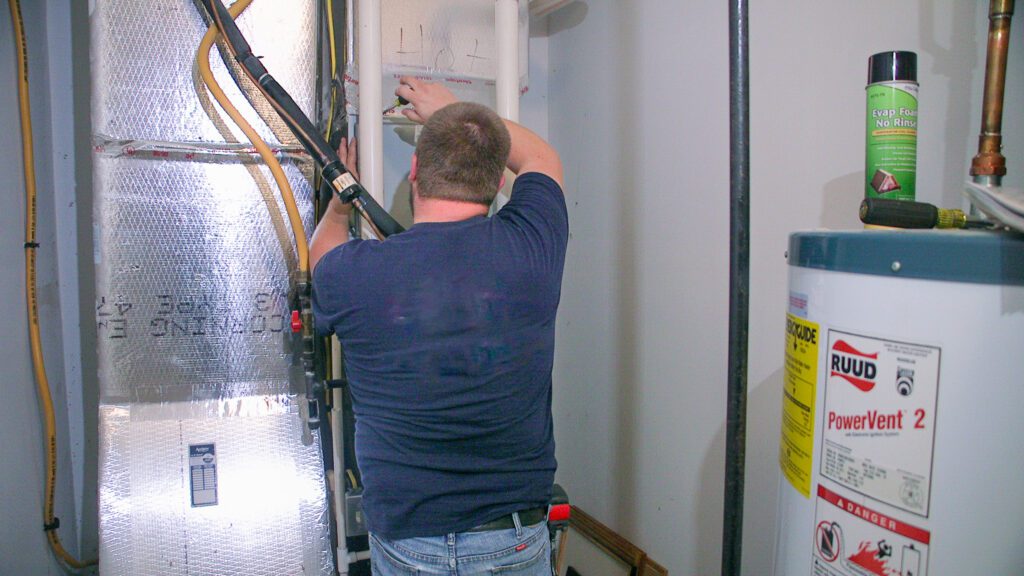 A Goodridge Construction technician performing commercial HVAC installation on a new system, supporting replacement services, improving energy efficiency, and ensuring proper system optimization for a commercial building.