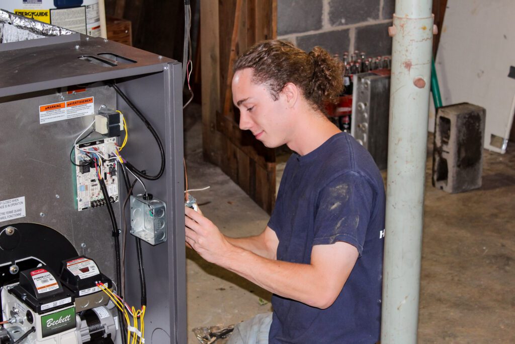 Residential HVAC Maintenance service and Repair is showcased with a Goodridge Construction professional HVAC technician servicing a furnace, highlighting the importance of Preventative HVAC maintenance and reliable HVAC maintenance and repairs.