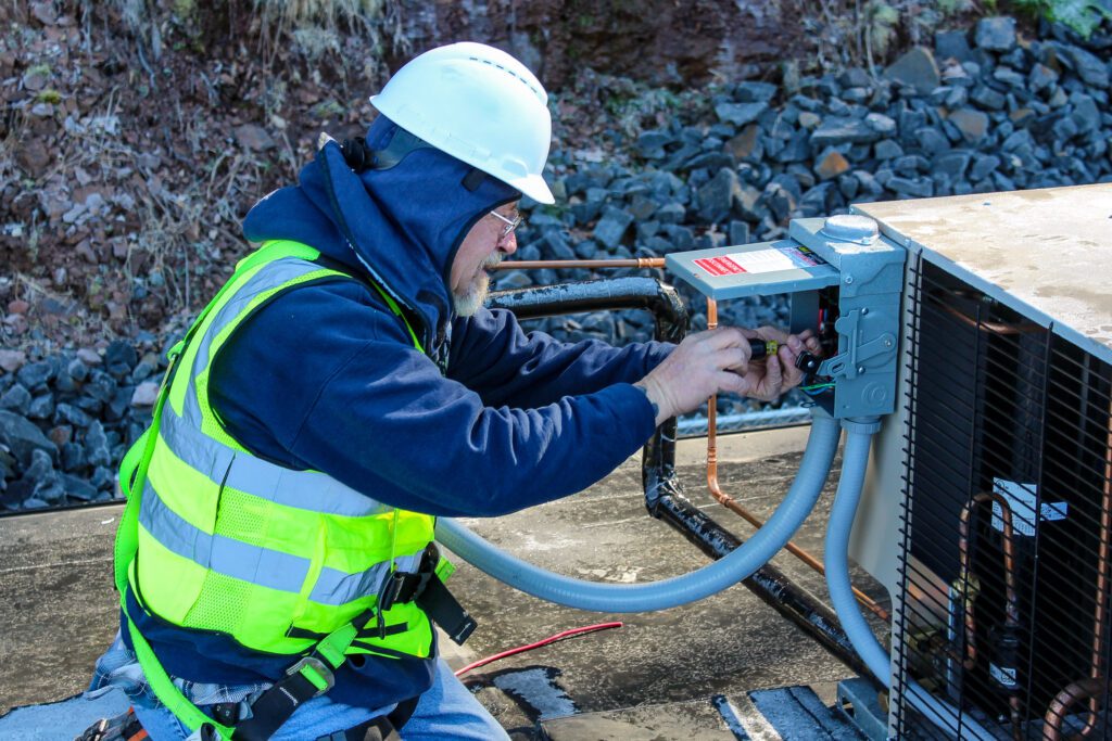 Professional electrician repairing a generator as part of energy efficiency & conservation efforts to maintain reliable home power.