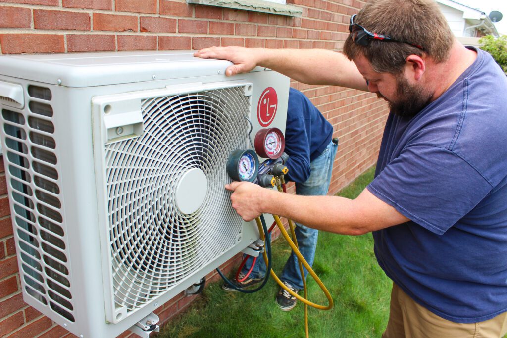 Residential HVAC services technicians using gauges and performing repairs exemplify Residential HVAC Inspection repair, including detailed HVAC system repair and a thorough indoor air quality services.