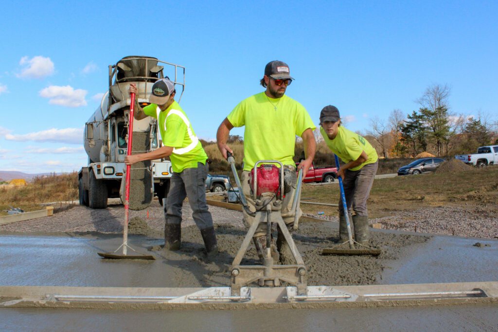Residential construction services in action as a concrete crew works on a driveway, demonstrating skilled craftsmanship, quality materials, and precise execution.