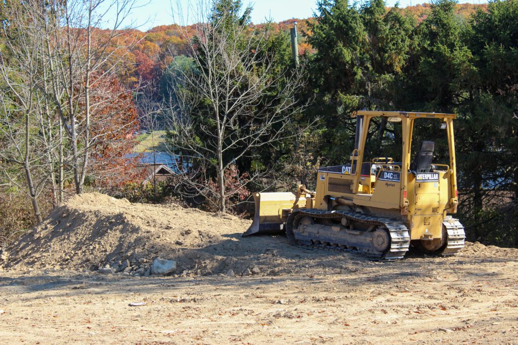 A bulldozer levels a commercial site as part of expert general construction, preparing foundations for safe and durable buildings.